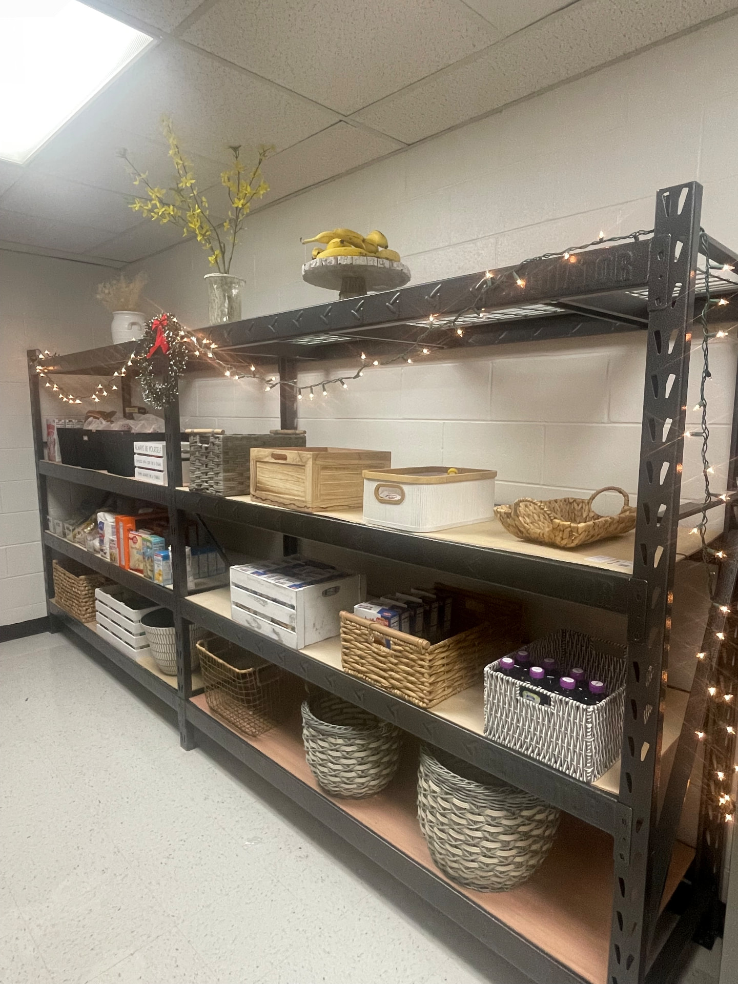 Pantry shelves organized with baskets, books, and string lights