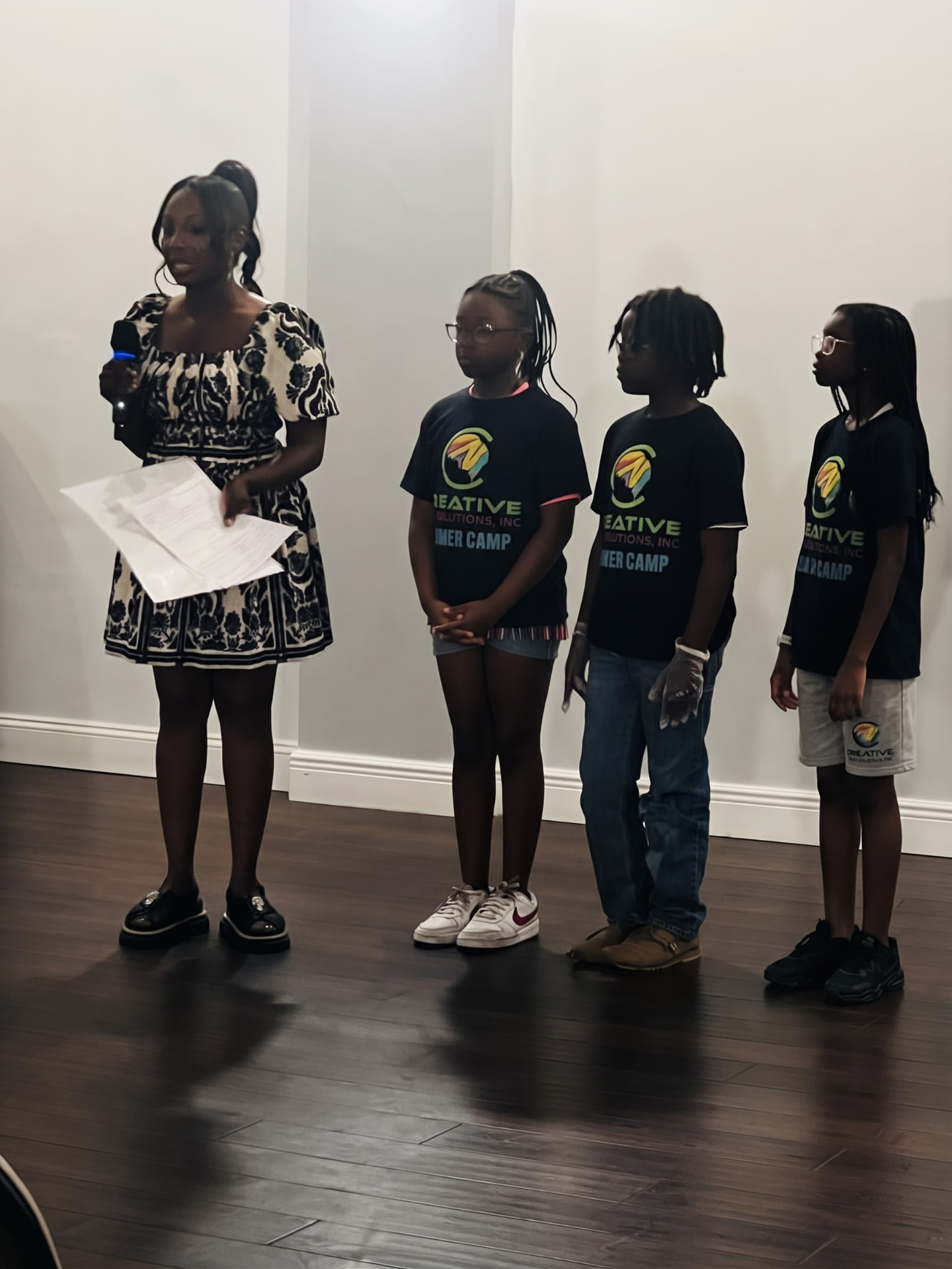Students in summer camp shirts presenting with their teacher